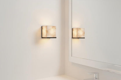 Two wall-mounted lights on a white wall with a mirror reflection.