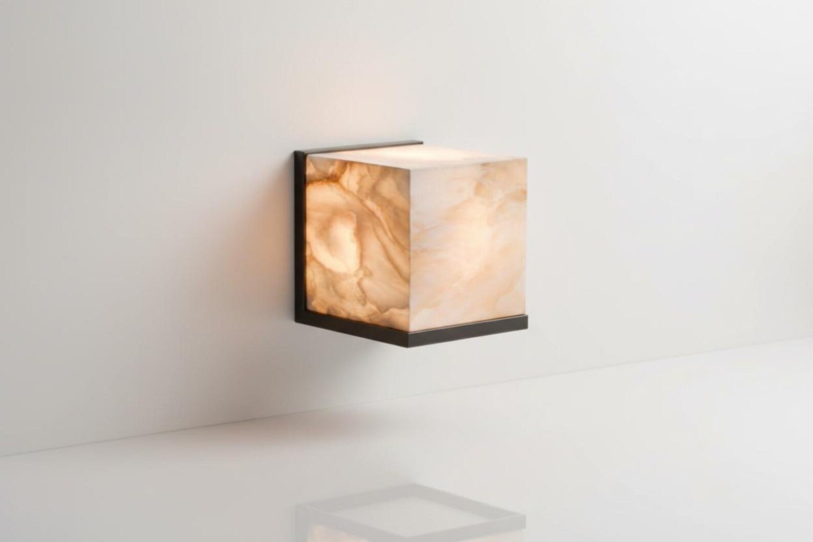 Square wall light with marble-like finish on a white wall