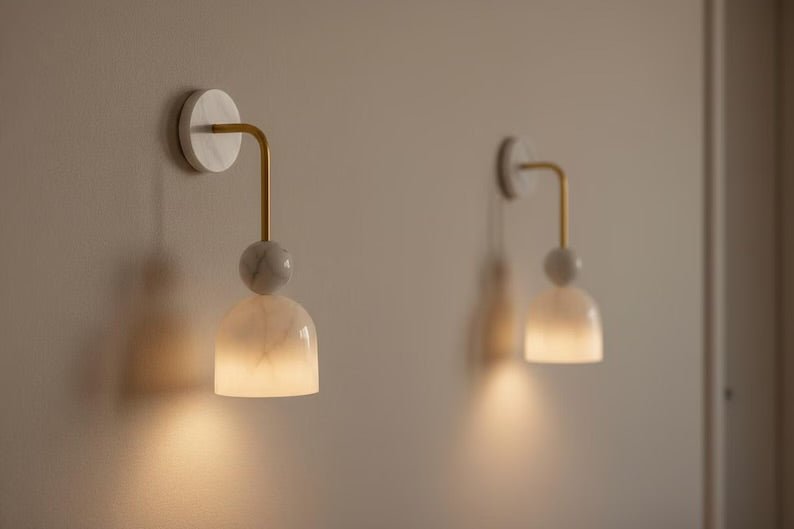 Double alabaster marble wall sconces with brass arms and soft diffused light