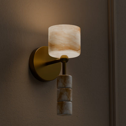 Alabaster wall light with brass finish emitting soft warm glow in dim interior setting
