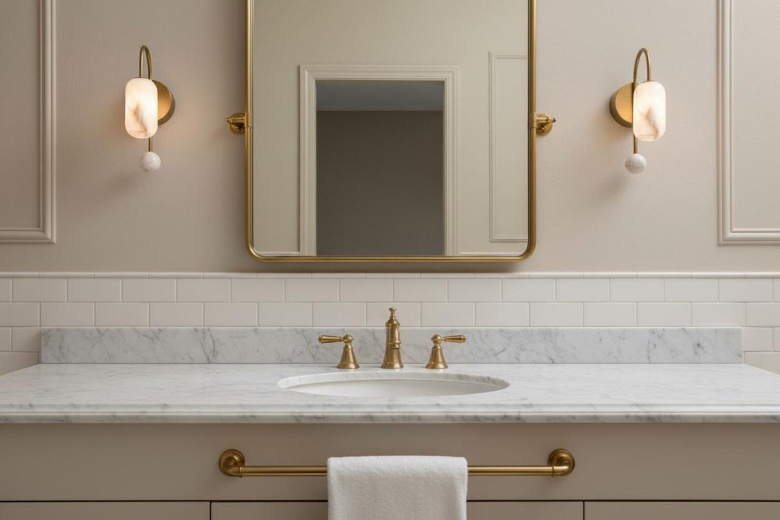 Bathroom vanity with marble countertop, sink, and gold fixtures.