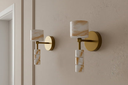 Pair of alabaster wall sconces with brass finish installed symmetrically on interior wall

