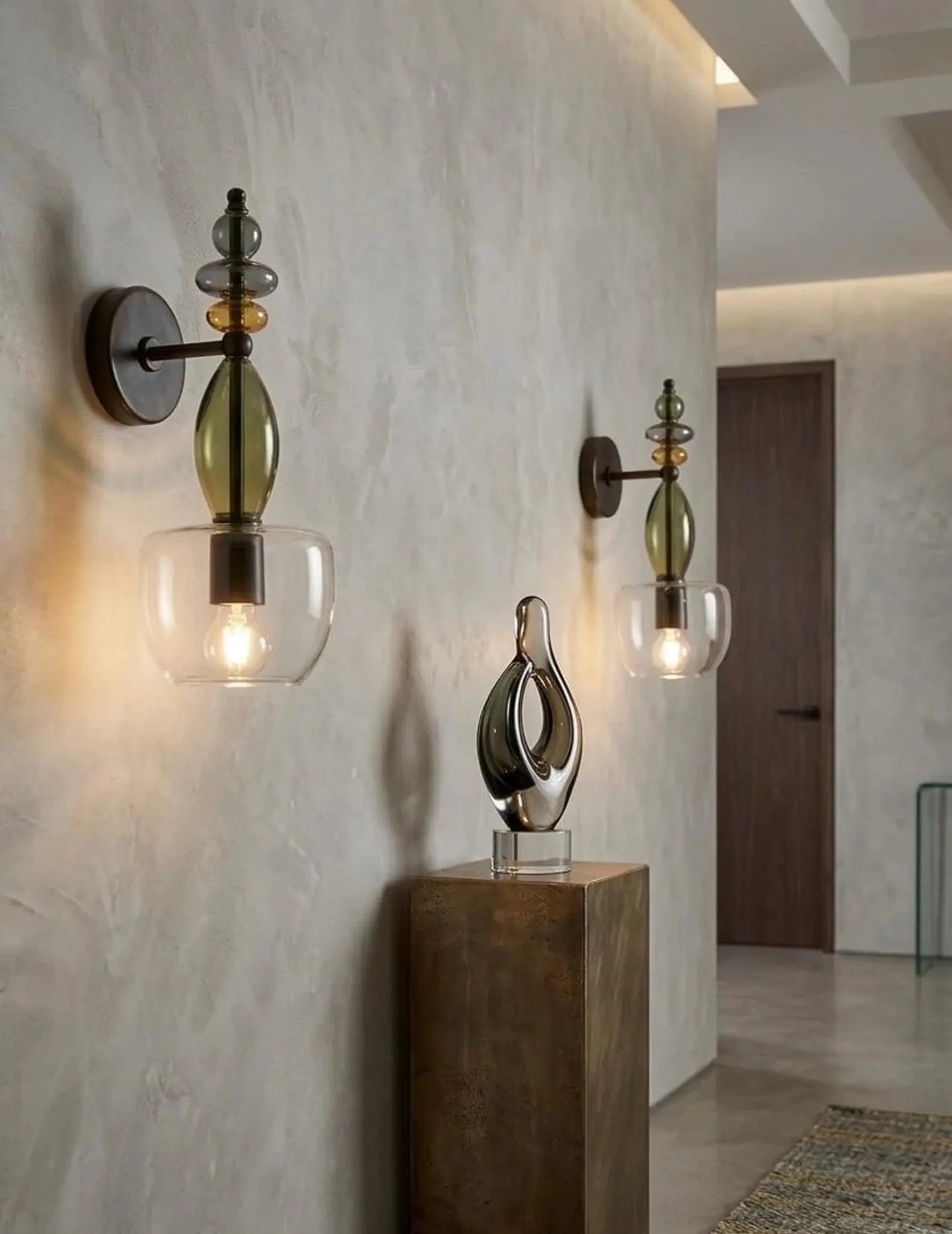 Decorative wall sconces with glass shades on a textured wall.