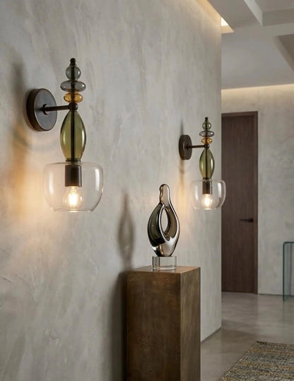 Decorative wall sconces with glass shades on a textured wall.
