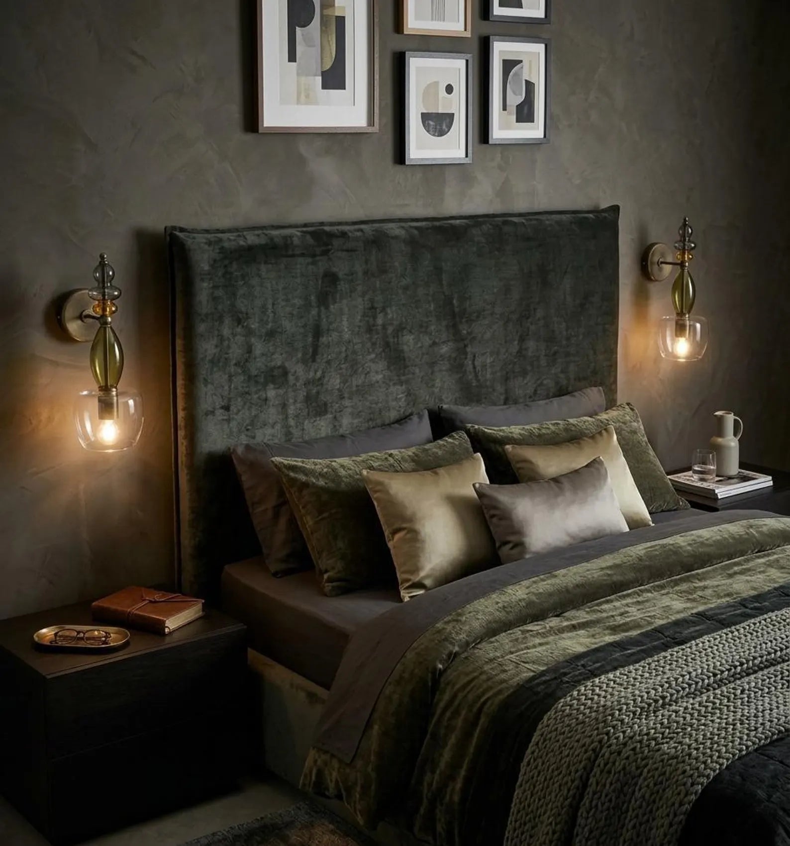 Dark-themed bedroom with a textured headboard, framed art on the wall, and soft lighting.