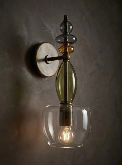 Decorative wall sconce with glass shade and vintage-style design on a dark background