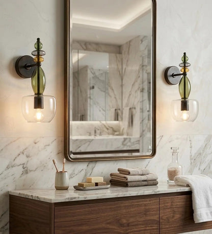 Bathroom vanity with mirror, lights, and toiletries against a marble wall.