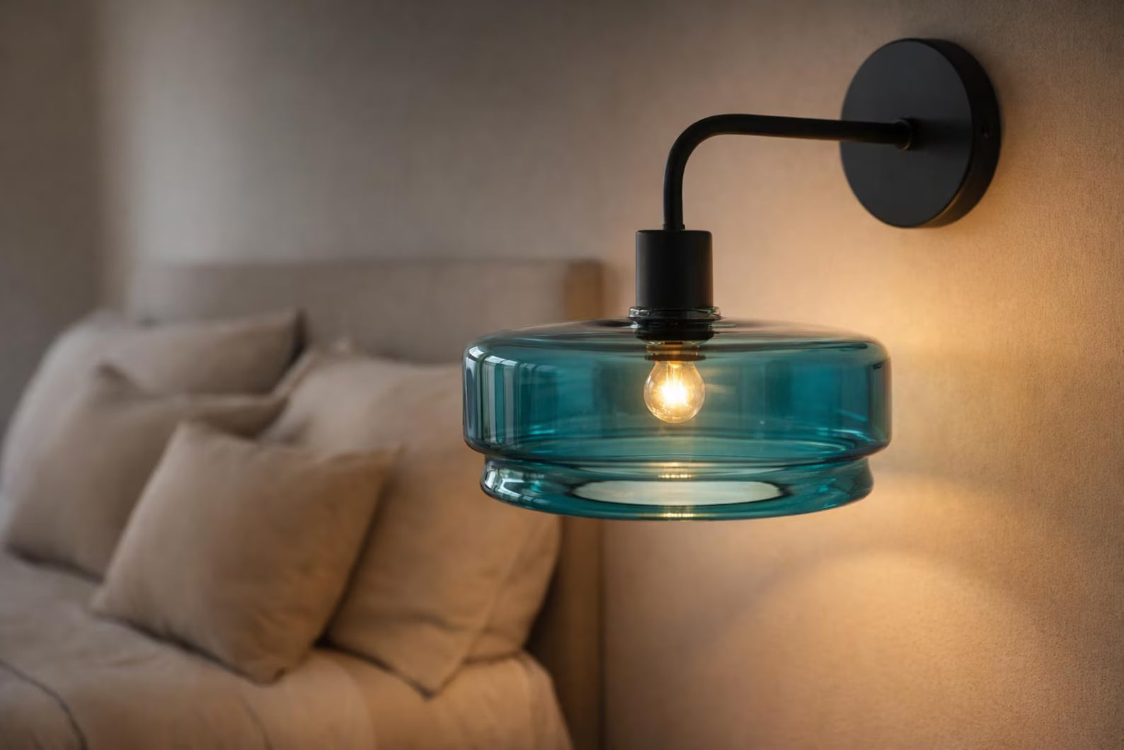 Blue wall-mounted lamp with a beige sofa and pillows in the background