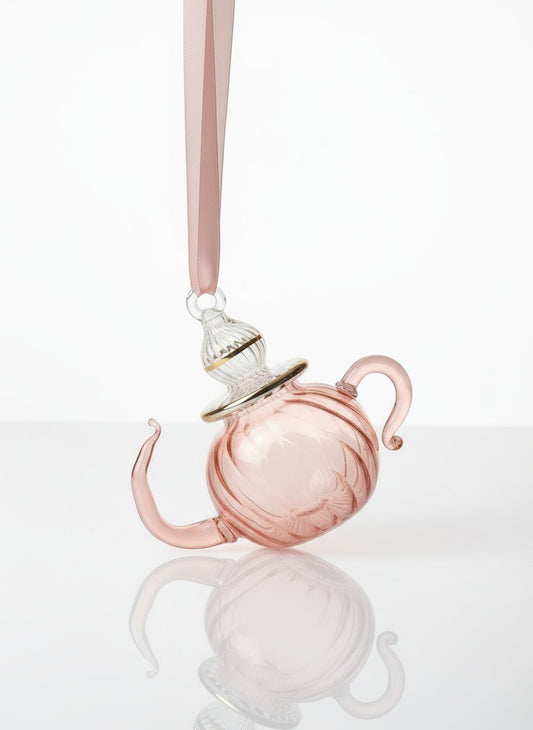 Pink teapot-shaped ornament on a white background