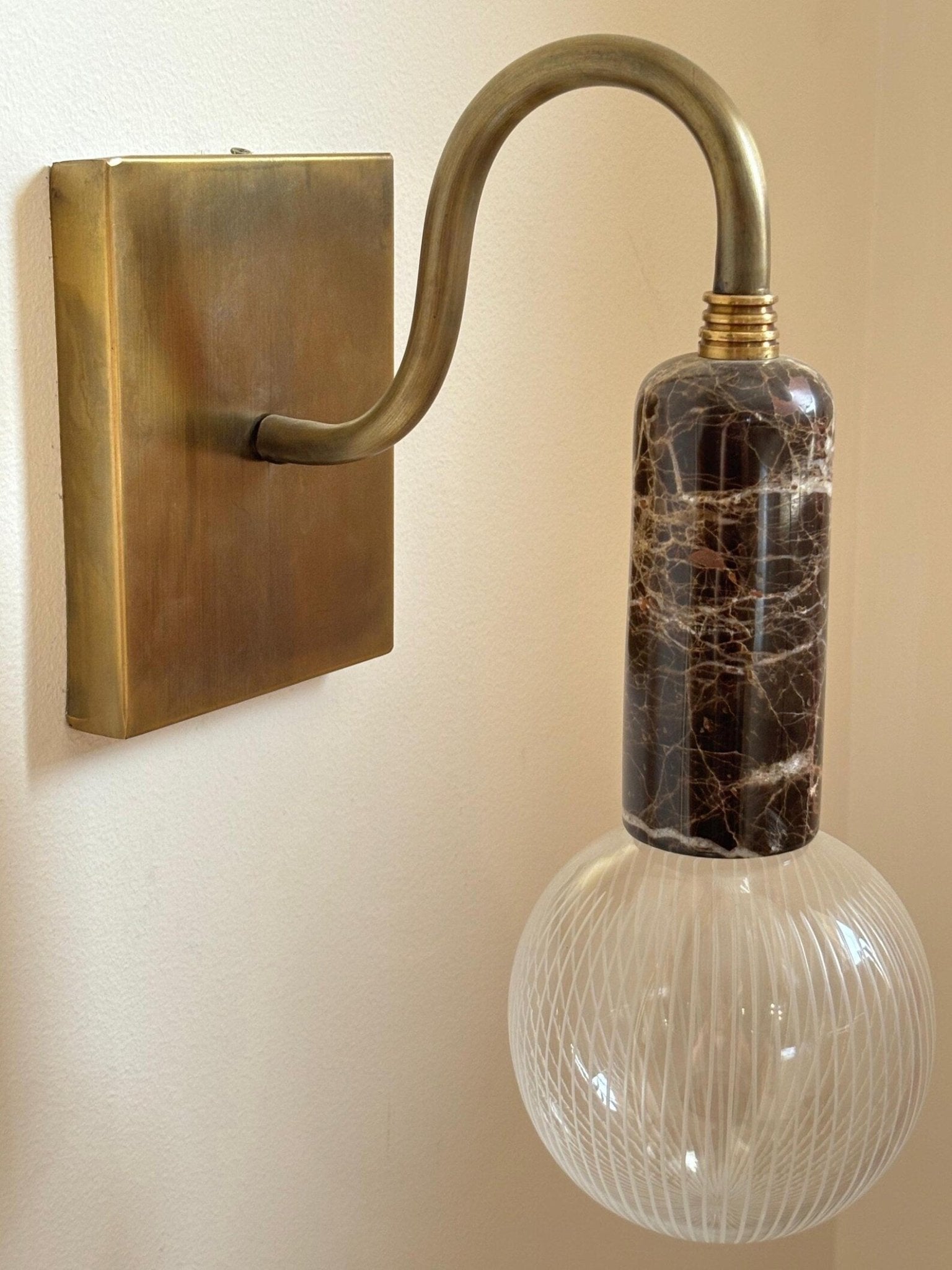 Wall-mounted light fixture with marble-textured bulb.
