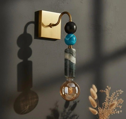 Decorative wall sconce with beads on a dark wall