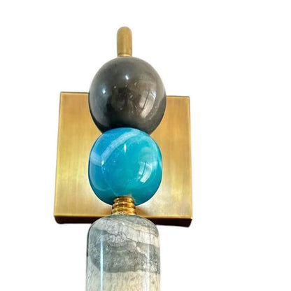 Decorative wall sconce with glass spheres on a white background