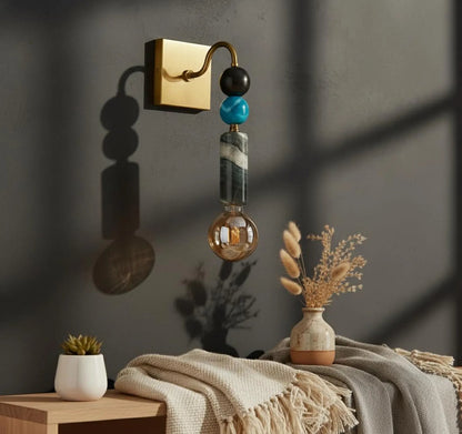 Decorative wall sconce with colorful beads on a dark wall background