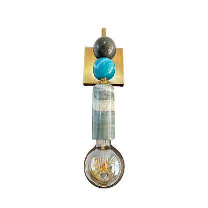 Decorative wall light fixture with a gold square base, turquoise sphere, and clear glass shade on a white background.