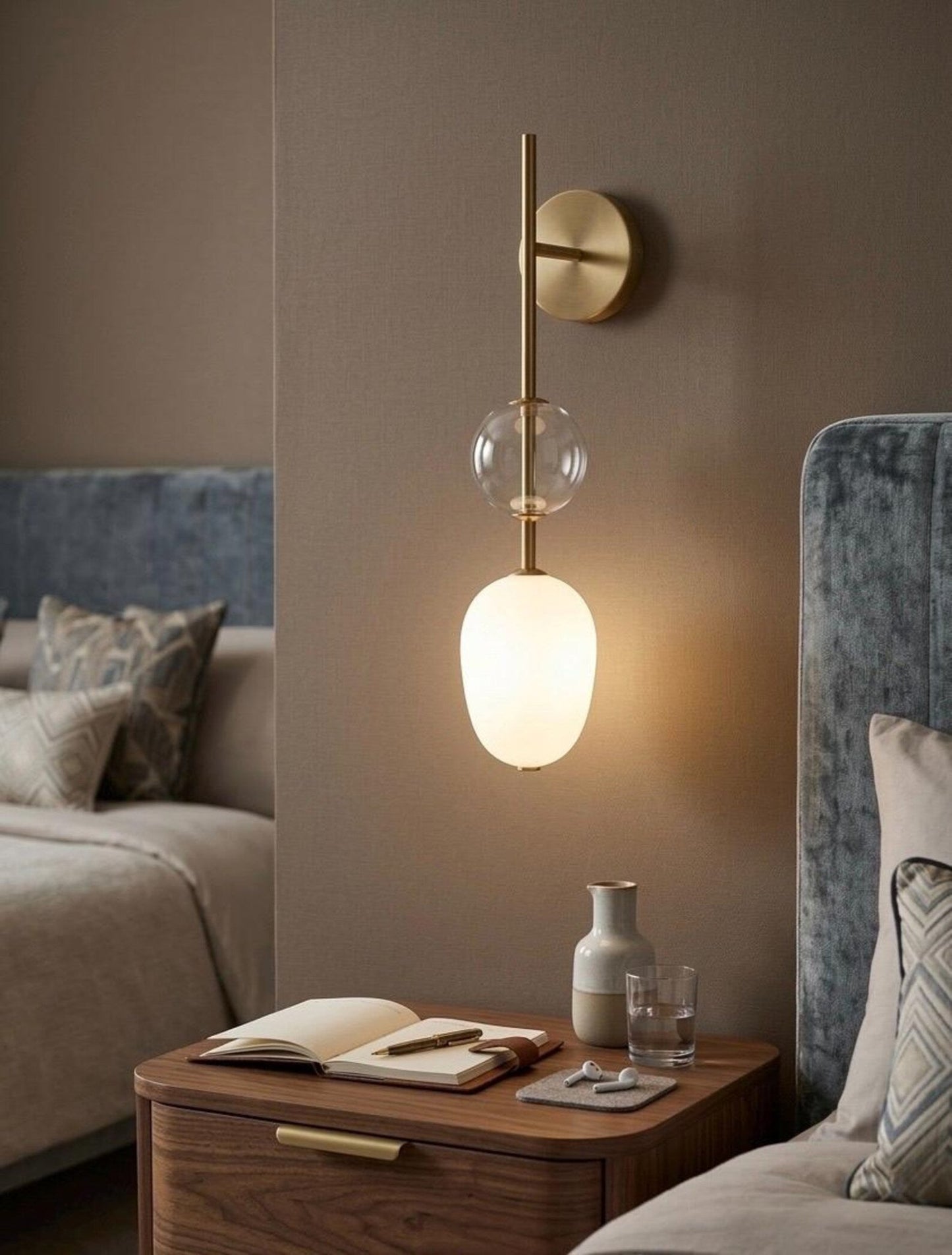 Modern wall sconce with glass shades in a bedroom setting.