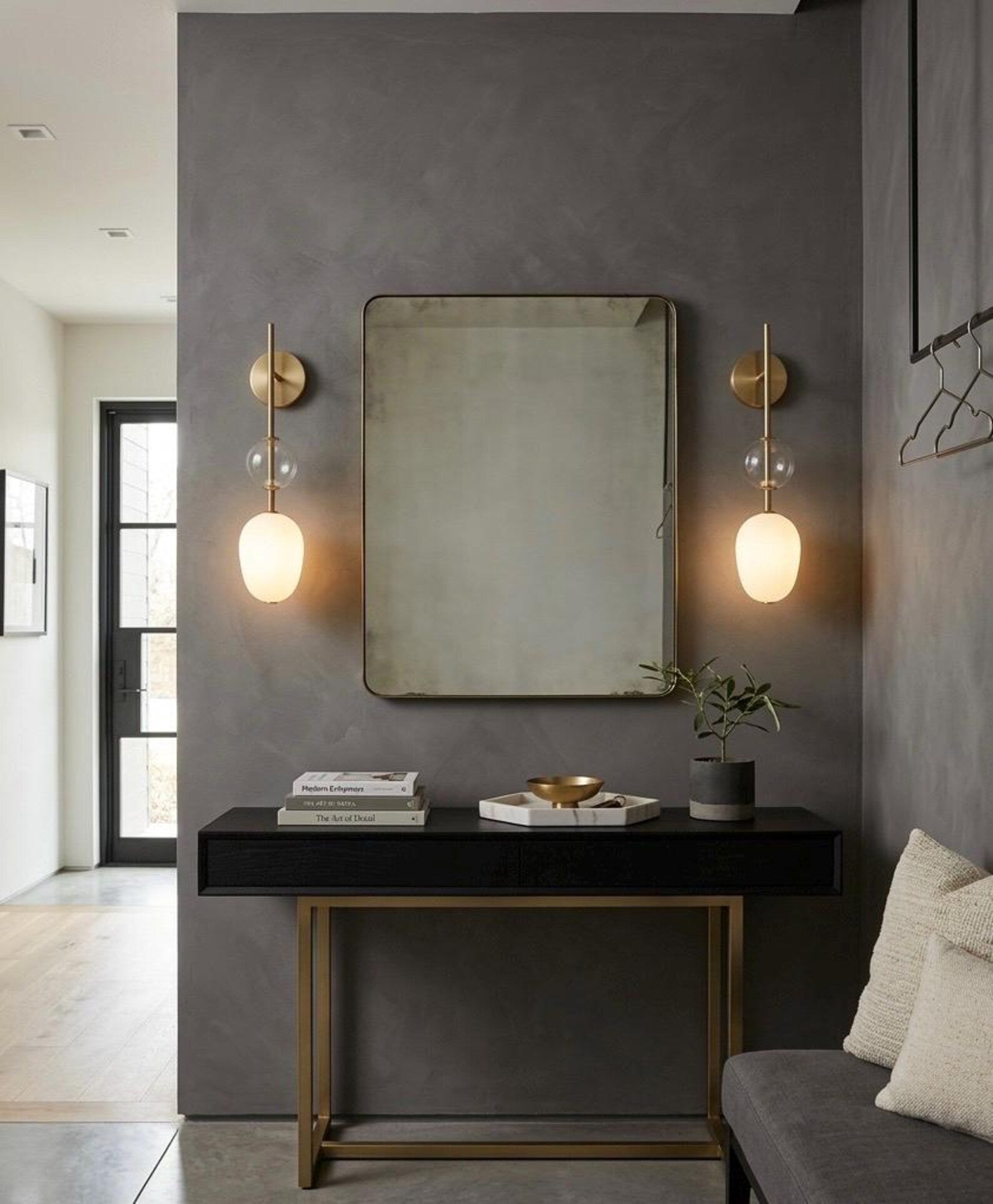 Modern interior design with a mirror, lights, and decor on a gray wall.