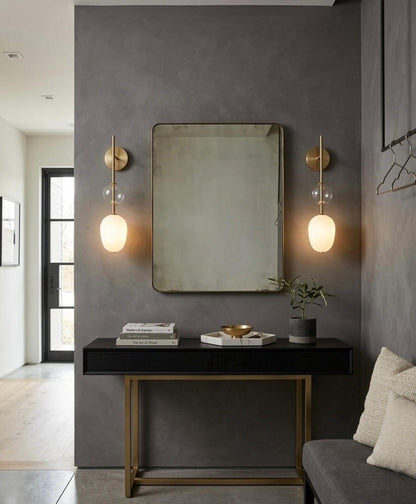 Modern interior design with a mirror, lights, and decor on a gray wall.