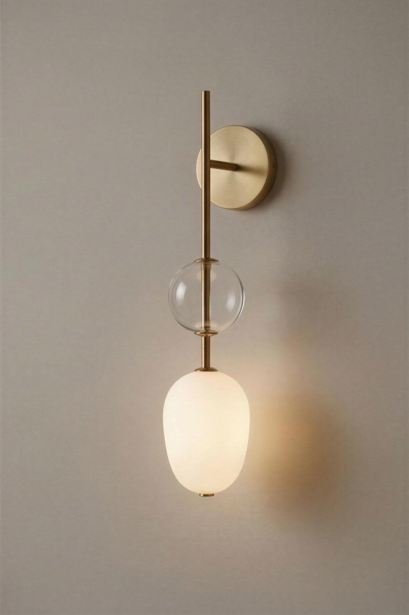 Wall-mounted light fixture with glass shades on a neutral background