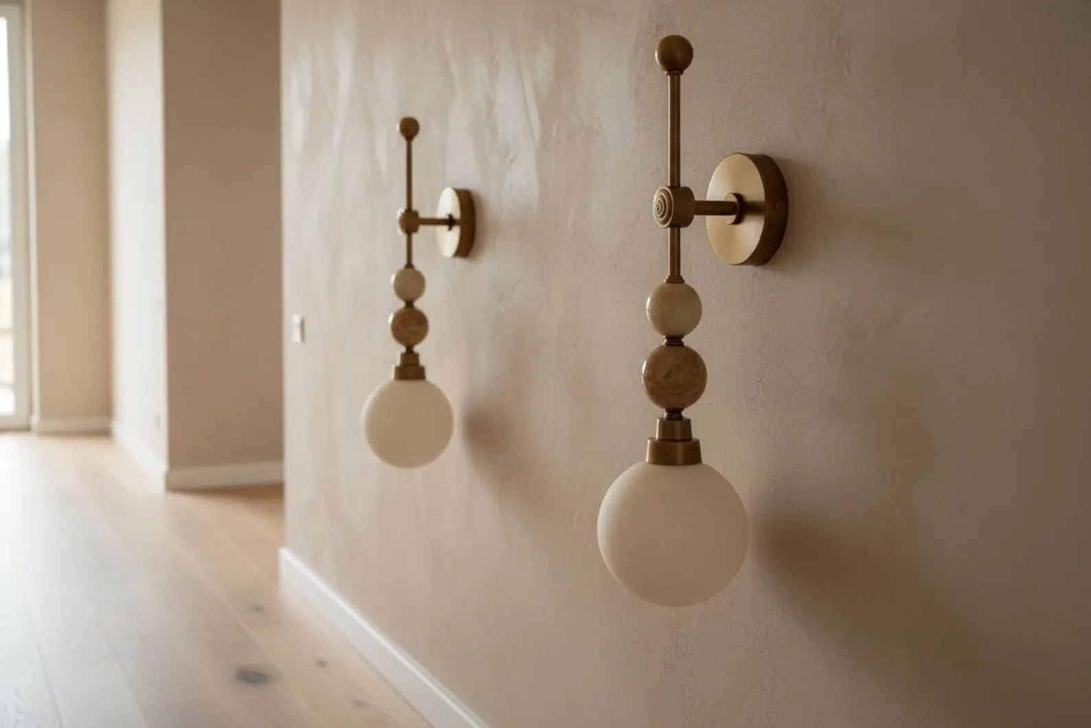 Two wall-mounted lights with spherical bulbs on a beige wall.