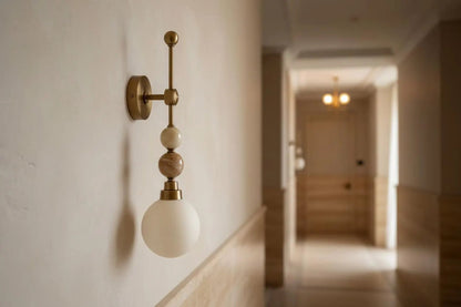Wall-mounted light fixture with a blurred hallway in the background
