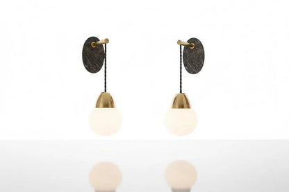 Two wall-mounted light fixtures with round glass shades on a white background