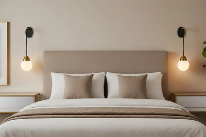 Neatly made bed with beige and white bedding in a bedroom setting.