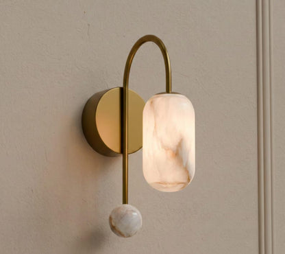 Wall-mounted light fixture with marble-like glass shade on a neutral wall.