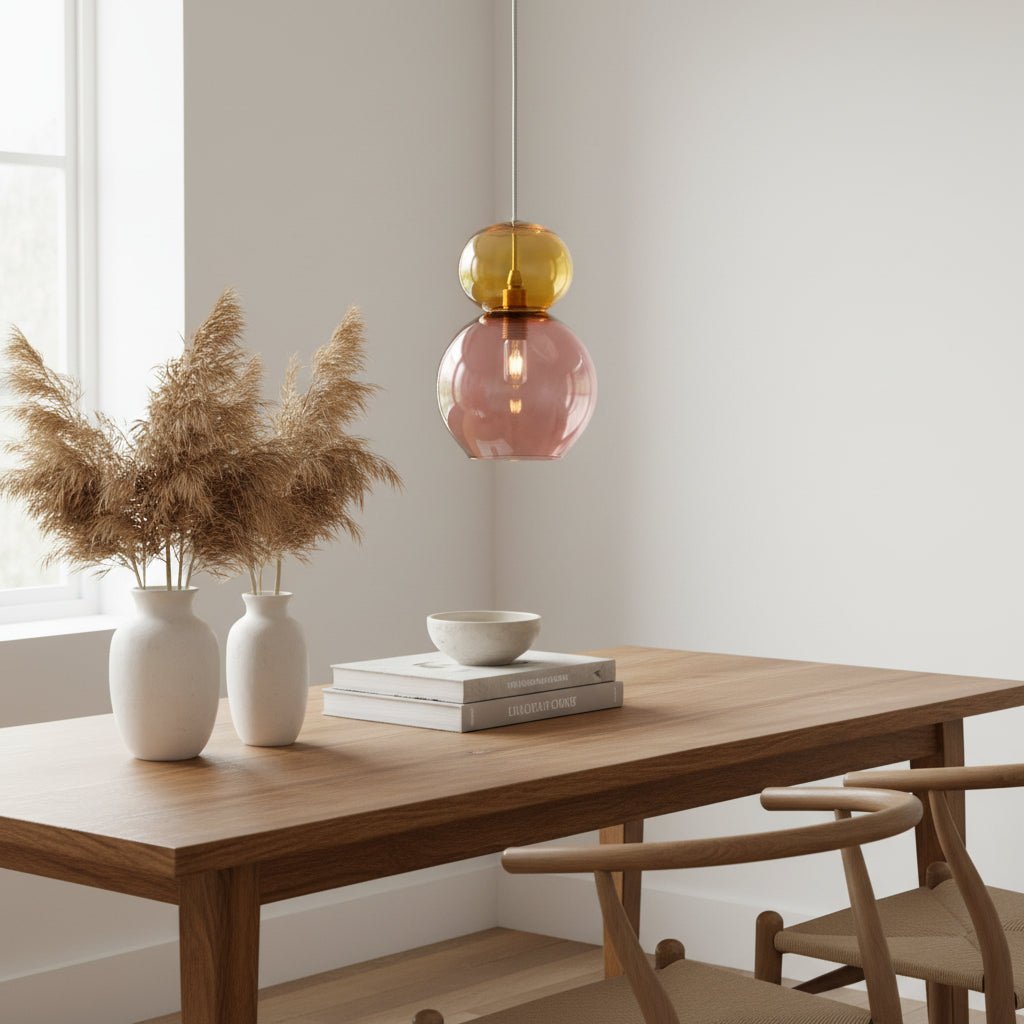 Pendant light with yellow top and pink bottom on a white background
