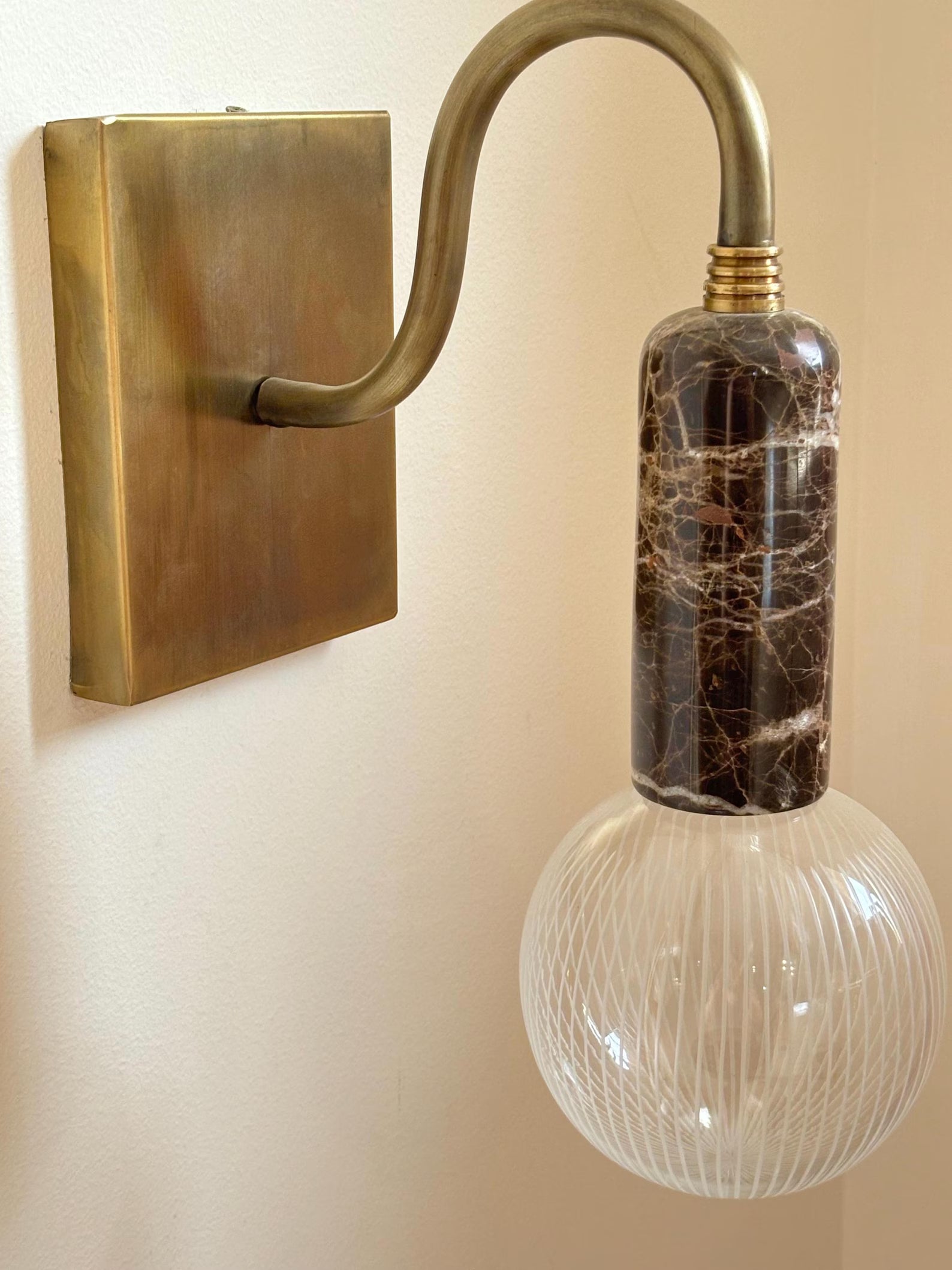Wall-mounted light fixture with a decorative glass bulb.