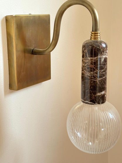 Wall-mounted light fixture with a decorative glass bulb.