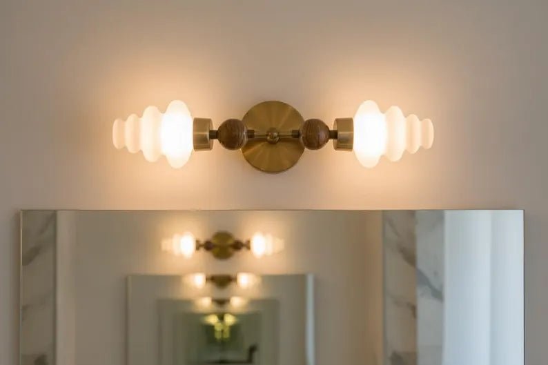 Double brass wall sconce with frosted glass shades used above bathroom mirror