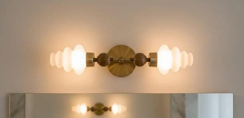 Handmade double wall sconce in brass with frosted glass shades and soft light