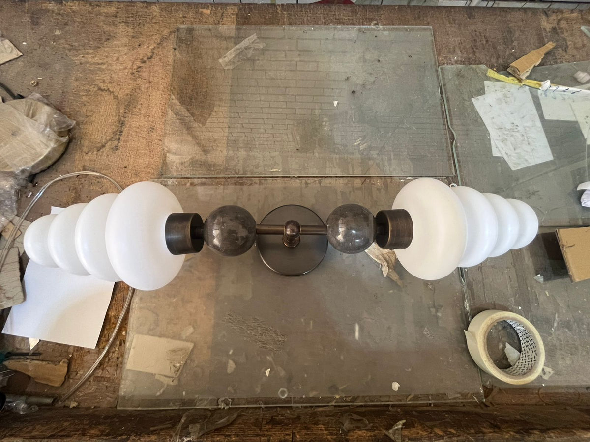 Double brass wall sconce with frosted glass shades and onyx stone details