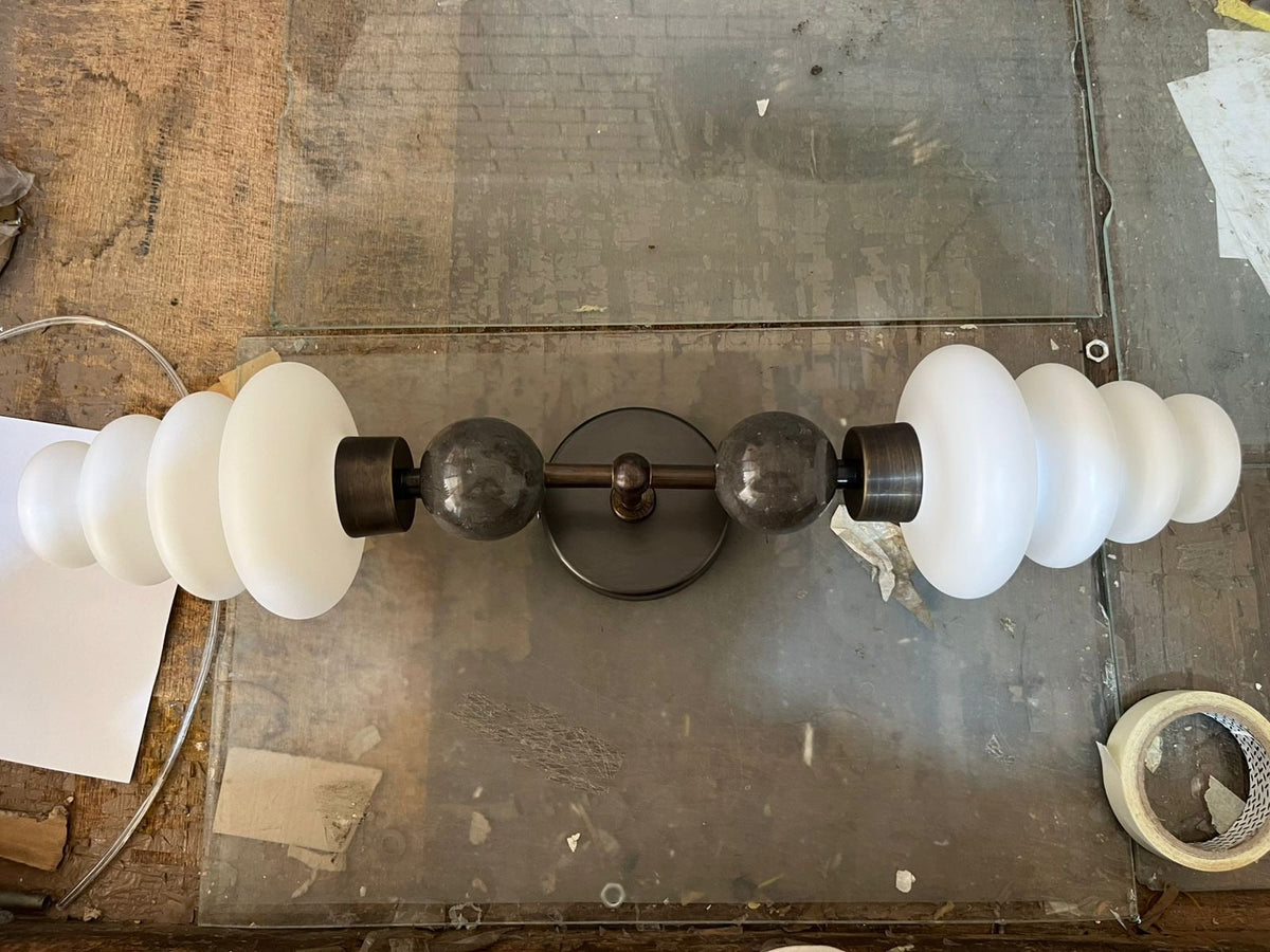 Double brass wall sconce with frosted glass shades and onyx stone details
