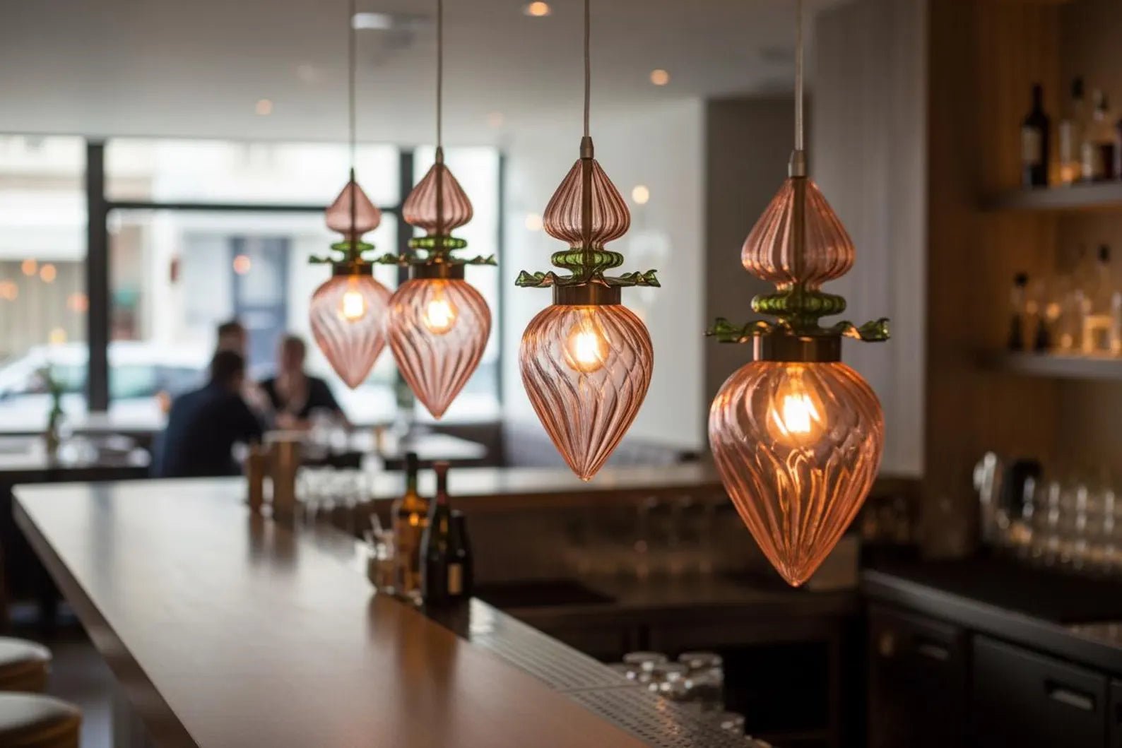 Decorative pendant lights hanging above a bar counter in a modern interior setting - Les Trois Pyramides