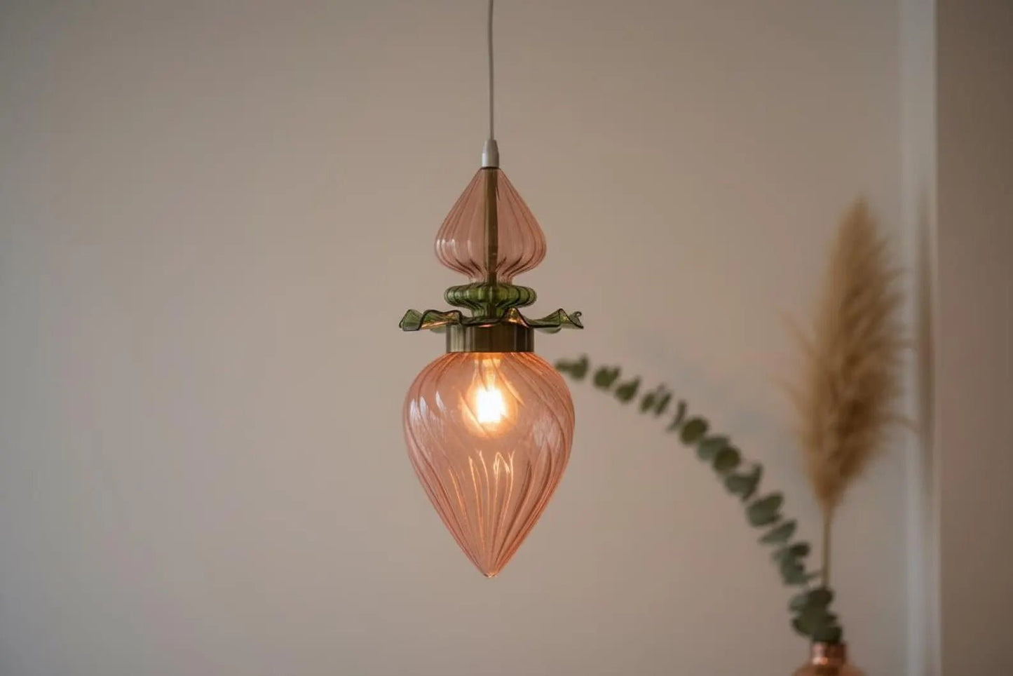 Flower pendant light with a blurred plant in the background  - Les Trois Pyramides