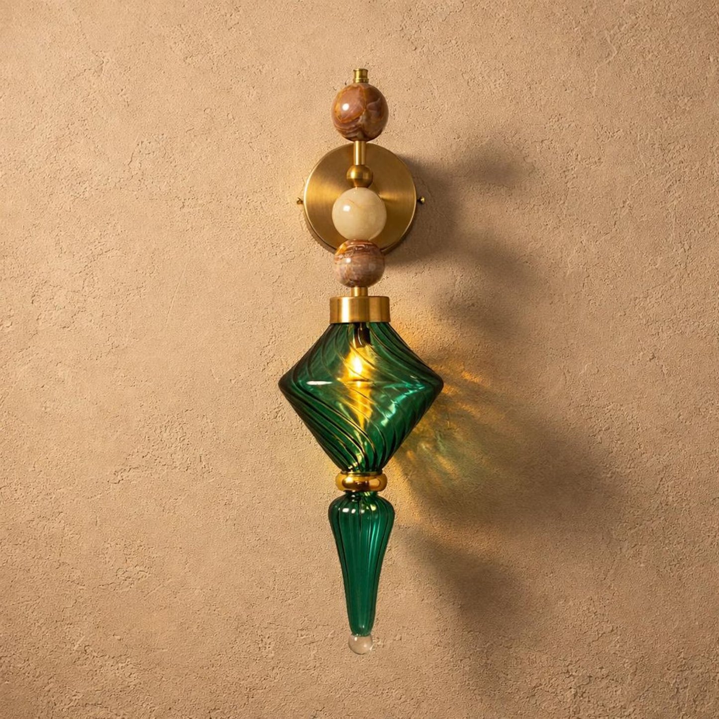 Decorative wall sconce with green glass and wooden accents on a beige wall.