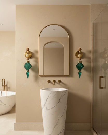 Bathroom interior with a marble sink, decorative mirror, and wall sconces.