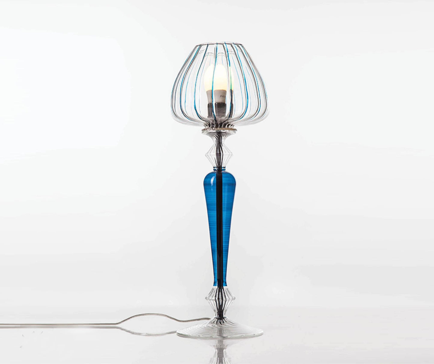 Decorative table lamp with blue and clear glass design on a white background