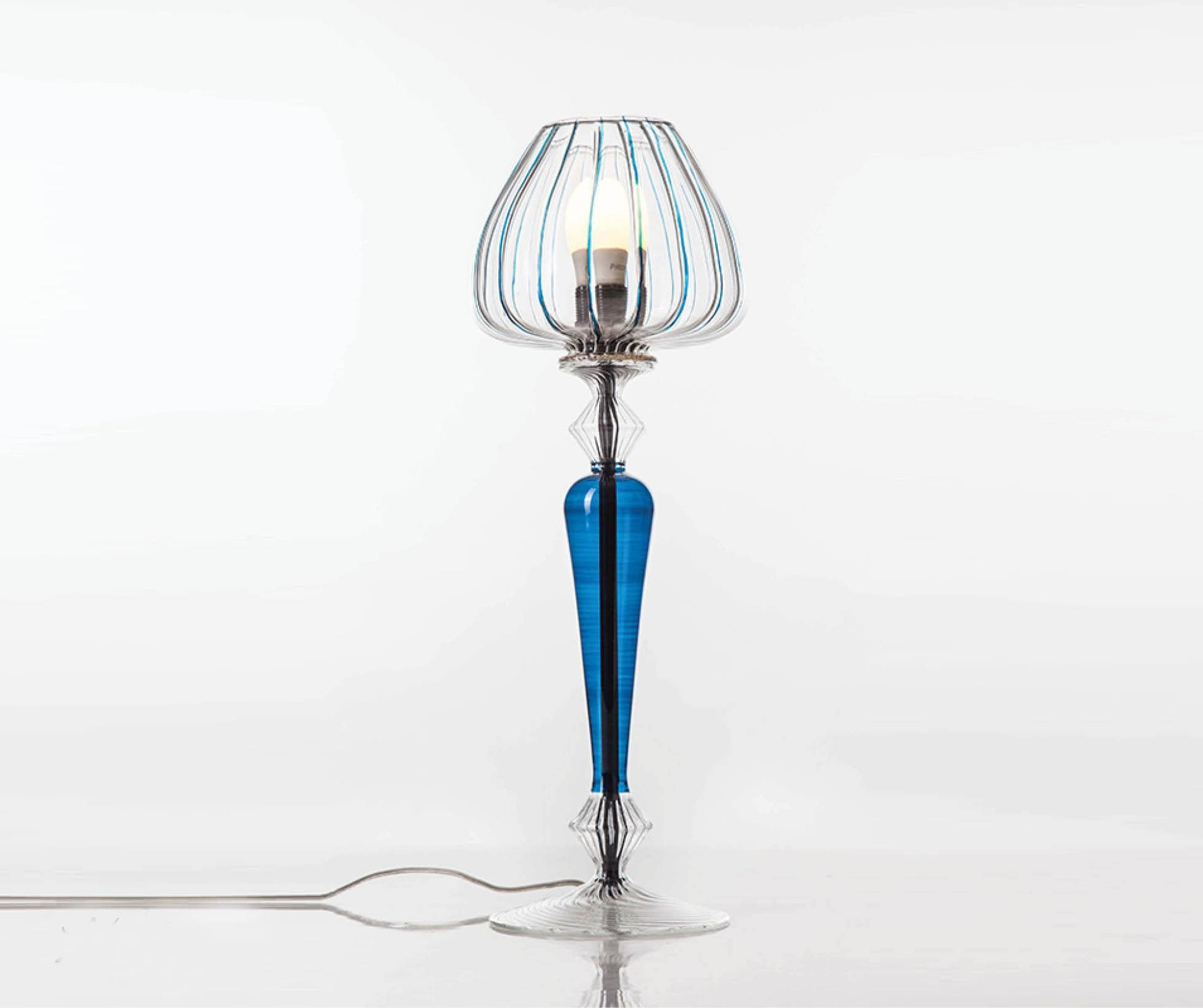 Decorative table lamp with blue and clear glass design on a white background
