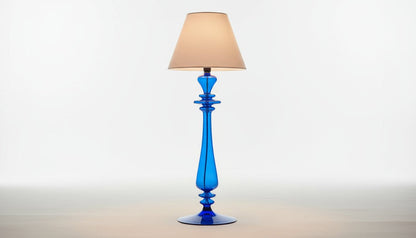 Blue lamp with white shade on a table in a room with decor elements.