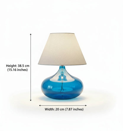 Blue glass table lamp with a beige lampshade on a white background