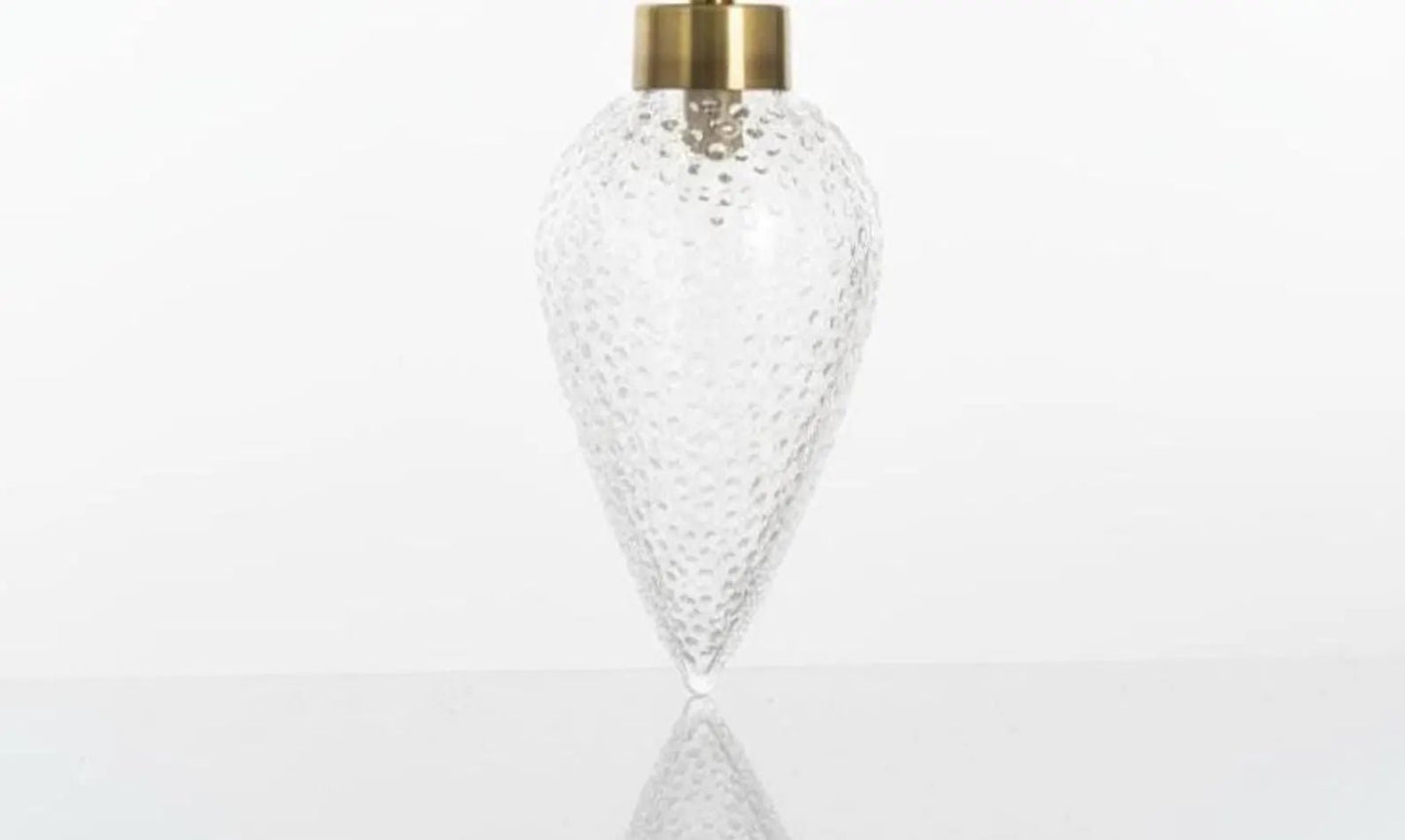 Clear glass vase with gold cap on a white background