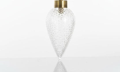 Clear glass vase with gold cap on a white background