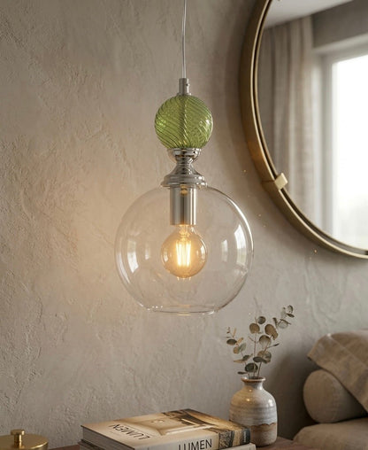 Pendant light with green glass shade and clear bulb in a cozy room setting - Les Trois Pyramides