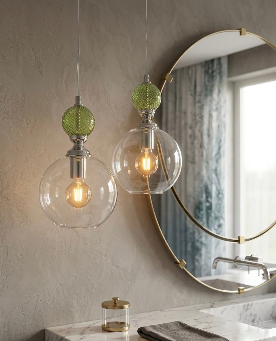 Modern pendant lights with glass shades and green accents hanging above a bathroom vanity - Les Trois Pyramides