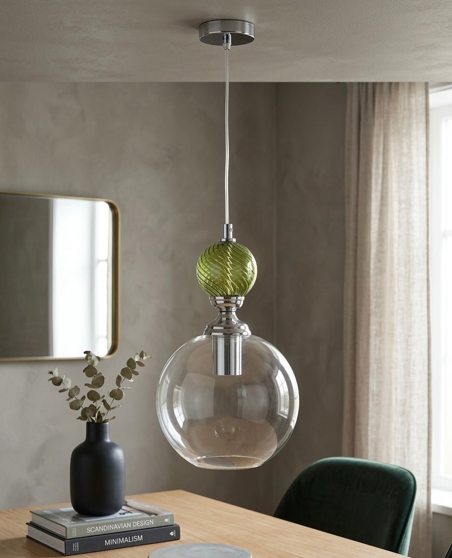 Modern pendant light with green and clear glass shades hanging above a table - Les Trois Pyramides