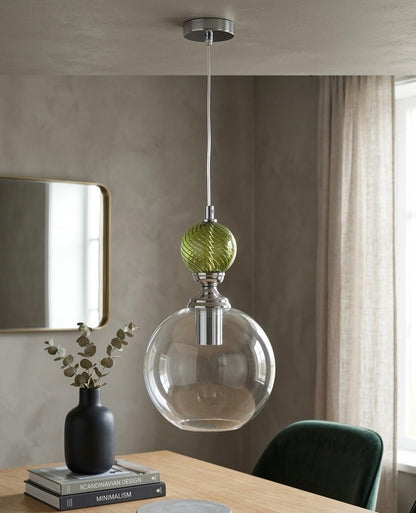 Modern pendant light with green and clear glass shades hanging above a table - Les Trois Pyramides