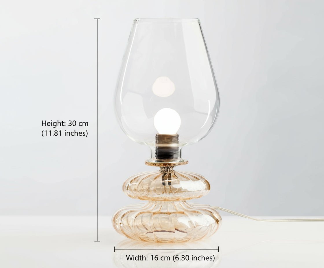 Glass table lamp with a clear glass shade on a white background