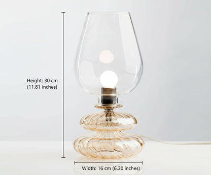 Glass table lamp with a clear glass shade on a white background